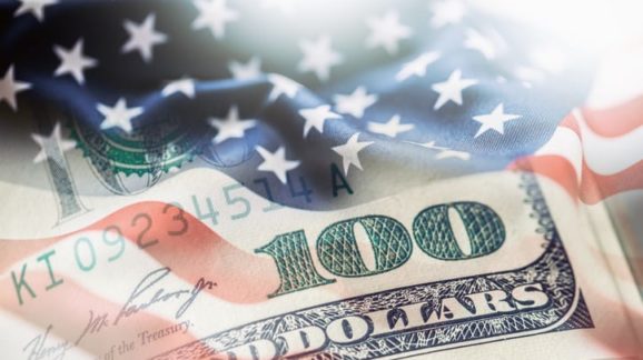 $100 and flag GettyImages-672847562